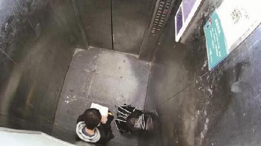 男孩被困電梯 淡定蹲下寫作業